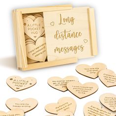 some wooden hearts are in a box with the words long distance messages written on them