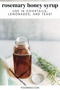 a glass jar filled with honey syrup on top of a table