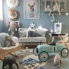 a child's playroom with toys and stuffed animals on the floor in front of blue walls