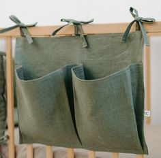 two green bags hanging from the side of a crib