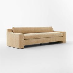 a beige couch sitting on top of a white floor