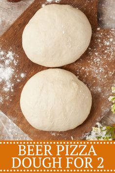 two doughnuts sitting on top of a wooden cutting board with powdered sugar