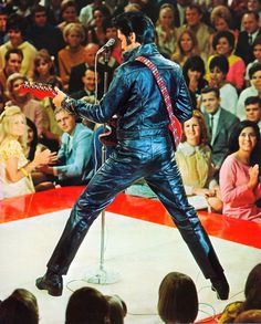 elvis presley performing on stage in front of an audience