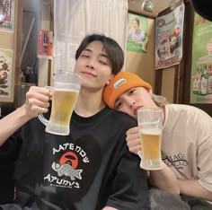 two young men are drinking beer together