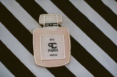 a pink and black striped table cloth with a bottle of perfume on it that says no 2 paris