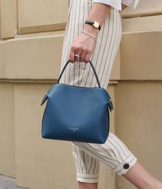 Pacific Blue embodies the serenity and tranquility of the marine depths. Designed to suit both a formal look and a casual outfit, this versatile handbag is as adaptable as you are. Handcrafted in our Italian workshop from grained calf leather, its robust design and golden finishes make it a reliable and elegant choice for any occasion.