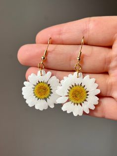 ➡️ [ITEM DESCRIPTION] Real wild white daisy flower, encased in UV resin. Average daisy flower has a 1" diameter. Lightweight, ultra white pedals, the perfect addition to any summer outfit. Earrings come in a variety of closures. See product specs below for more detailed information.  Metal closures and chain available in gold plated and stainless steel. All closures and chains are hypoallergenic and nickel / lead free. ➡️ [AVAILABLE STYLES] *Daisy Earring *Daisy Necklace  --- Custom Orders Accep Spring White Birth Flower Jewelry, White Flower Earrings For Mother's Day, White Flower Earrings For Mother's Day Gift, White Flower Earrings As Mother's Day Gift, Everyday White Birth Flower Jewelry, Adjustable White Flower Earrings For Spring, White Flower Jewelry With Birth Flower Detail, Mother's Day Birth Flower Earrings, White Daisy Flower Earrings For Spring