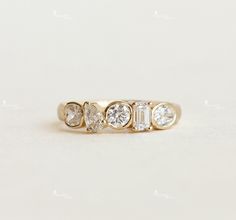 a gold ring with five diamonds on it