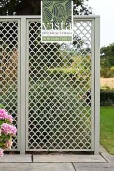 a white fence with pink flowers in front of it and the words vista decorative screens