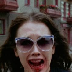 a woman with sunglasses and blood on her face