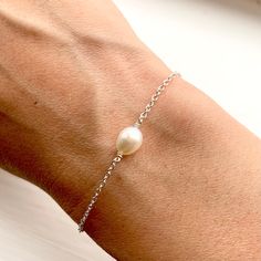 A B O U T : An elegant and dainty silver freshwater pearl chain bracelet.  Perfect for a bridesmaids gift. For a special occasion and everyday wear.  Gold variations and matching earring available. M E A S U R E M E N T S : Pearl size, 6mm long. Chain, 1.2mm thick. Length - standard 7 inches, small or large are available to choose. Please let me know if another length is required as I can make any length. M A T E R I A L S : Freshwater pearl and sterling silver. All materials sourced locally. P White Gold Pearl Bracelet As Gift, Pearl White Bracelet With Pearl Pendant As Gift, Pearl Pendant Bracelet As Gift, Pearl Pendant Bracelet Perfect For Gift, Gift White Gold Bracelet With Pearl Drop, Dainty Sterling Silver Pearl Bracelet With Charm, Dainty Sterling Silver Pearl Bracelet, Silver Pearl Bracelet With Pearl Drop For Gift, Silver Pearl Bracelet With Pearl Drop As Gift