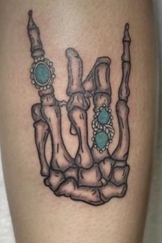 a tattoo on the leg of a person that has a hand with two fingers in it