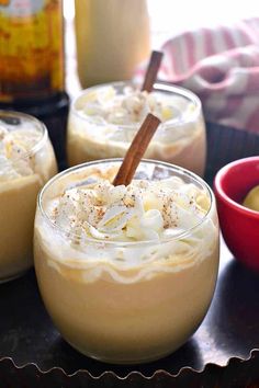 two glasses filled with dessert sitting on top of a table