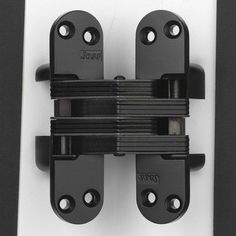 two black latches on the side of a white door