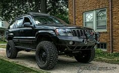 a black jeep parked in front of a brick building