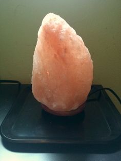 a pink rock sitting on top of a black tray