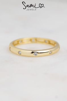 A gold multi-stone ring that is a minimalist piece. Minimalist Diamond Eternity Band For Everyday, Diamond Minimalist Everyday Eternity Band, Minimalist Everyday Diamond Eternity Band, Everyday Timeless Stackable Diamond Ring, Timeless Stackable Diamond Ring For Everyday, Minimalist Diamond Eternity Band, Minimalist Everyday Stackable Rings With Halo, Elegant Everyday Stackable Rings With Bezel Setting, Elegant Everyday Stackable Rings