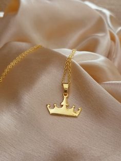 14k gold plated crown 👑 necklace '  The 14K Gold plated Crown Necklace is a delicate and dainty piece of jewelry that is perfect for any princess in your life. It features a tiny solid gold-plated crown pendant that is delicate and feminine, making it a perfect choice for those who prefer subtle and understated jewelry. This necklace is made from High quality Brass which is a high-quality and valuable metal that is resistant to tarnish and wear. It is the perfect gift for any special occasion, Gold Necklaces With Crown Design For Gifts, Dainty Jewelry With Crown Design For Gift, Dainty Jewelry With Crown Design As Gift, Understated Jewelry, Mini Crown, Crown Pendant, Princess Necklace, Crown Necklace, Gold Crown