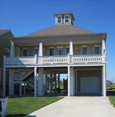 a two story house with white balconies on the second floor and an attached garage