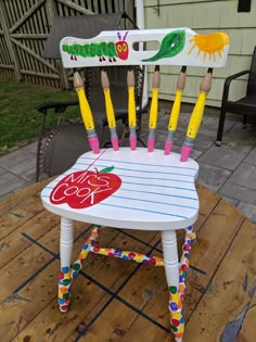 a child's chair made to look like an apple with pencils sticking out of it