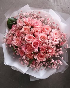 a bouquet of pink roses is sitting on the ground