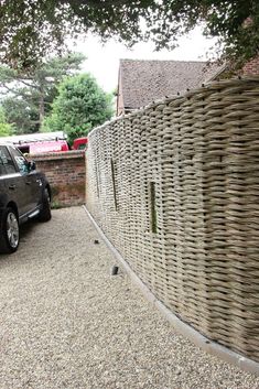 a car parked in front of a wall made out of wickers and gravel