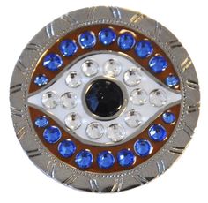 an evil eye brooch with blue and white crystals on it's center piece