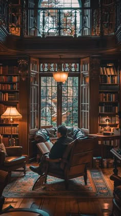 a man sitting in a chair looking out the window at bookshelves and lamps