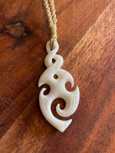 a white carved pendant sitting on top of a wooden table