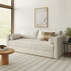 a living room with a white couch and coffee table in front of a large window