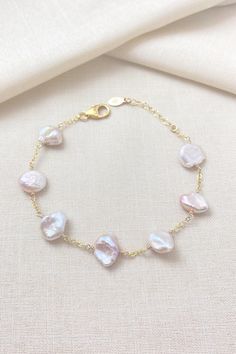 Pale pink keshi pearls adorn a shimmering gold-filled chain. These beautiful pearls each have a unique, organic shape, and the pink shades range from peach to mauve to light lavender. Bracelet length: 7.25-8.25 Materials: cultured freshwater keshi pearls GIFTING ~ Jewelry gift box included. ~ I am happy to ship directly to the recipient.  Enter their address during checkout. ~ If you would like a gift note included in the package, please leave the text of the note in the "Add a note to Marsh Creek Jewelry" message box at checkout. FREE SHIPPING ~ Orders ship within 2 business days. ~ Free shipping is First Class ~ Priority Mail and Express Shipping upgrades are available during checkout. RETURNS ~ Returns accepted within 30 days of delivery CARE ~ Polish metal components with a jewelry pol Delicate Baroque Pearl Bracelet With Pearl Chain, Delicate Baroque Pearl Chain Bracelet, Delicate Baroque Pearl Bracelet, Rose Gold Jewelry With Baroque Pearl Charm, Rose Gold Baroque Pearl Jewelry With Pearl Charm, Rose Gold Baroque Pearl Charm Jewelry, Pink Dainty Pearl Chain Jewelry, Single Strand Baroque Pearl Bracelet As Gift, Pink Single Strand Baroque Pearl Jewelry