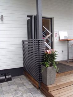 a planter with flowers is on the front porch