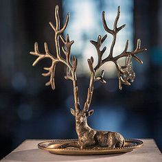 a deer figurine sitting on top of a golden plate