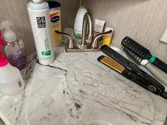 the bathroom counter is covered with different types of hair care products, including toothbrushes and shampoos