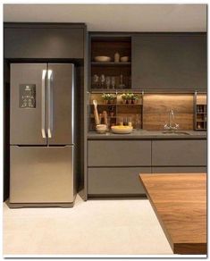 a metallic refrigerator freezer sitting inside of a kitchen