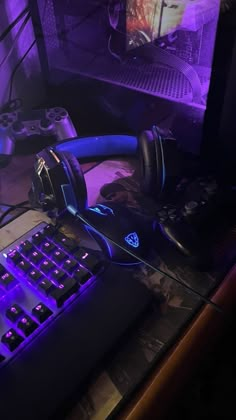 a gaming keyboard and headphones sitting on a desk in front of a computer monitor