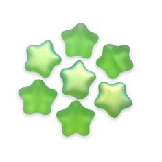 six green star shaped glass beads on a white background with space for text or image