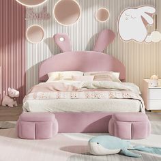 a pink bed in a bedroom with lots of round mirrors on the wall above it