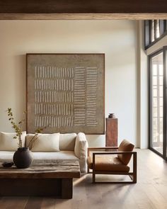 a living room filled with furniture and a large painting on the wall above it's fireplace