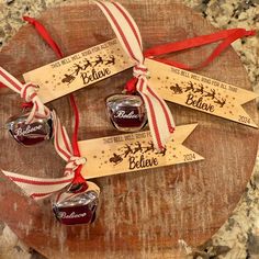 three personalized christmas ornament ornaments on top of a wooden board with ribbon