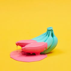 a bunch of bananas sitting on top of a pink and blue object in front of a yellow background