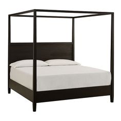 a bed with white sheets and black frame