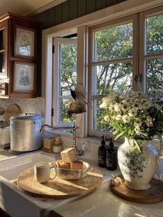 a kitchen with a sink, window and dishes on the counter