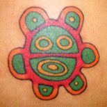 a colorful tattoo design on the back of a woman's shoulder, with circles and dots