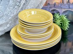 a stack of yellow and white plates sitting on top of a table