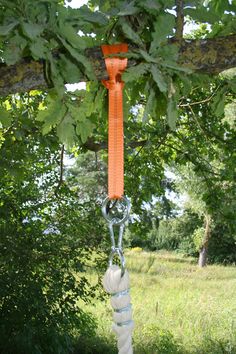 an orange and white rope hanging from a tree