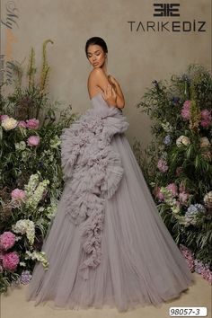 Looking for a breathtaking dress for your next big event? Check out the Tarik Ediz 98057 from the Spring 2022 evening collection. This gorgeous tulle gown is sure to make you stand out from the crowd. Whether you're attending a gala, wedding, or prom, this dress will have you feeling like a true celebrity on the red carpet. Tulle Dress Couture Candy, Blue Tulle Gown, High Fashion Gowns, Ruffle Tulle Dress, Gown Couture, Tulle Ruffles, Long Fitted Dresses, Lilac Blue, Tarik Ediz