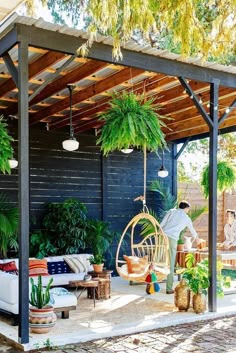 an outdoor living area with hanging chairs and potted plants