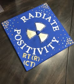 a blue and gold graduation cap with the words radiate positivity on it