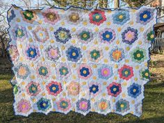 a large quilt is hanging on the grass